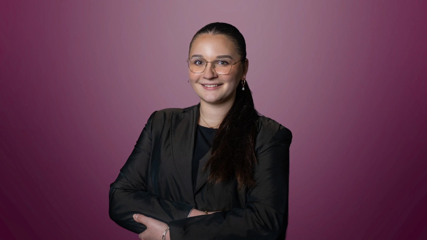 Ronja Isabella im Blazer vor beerenrotem Hintergrund